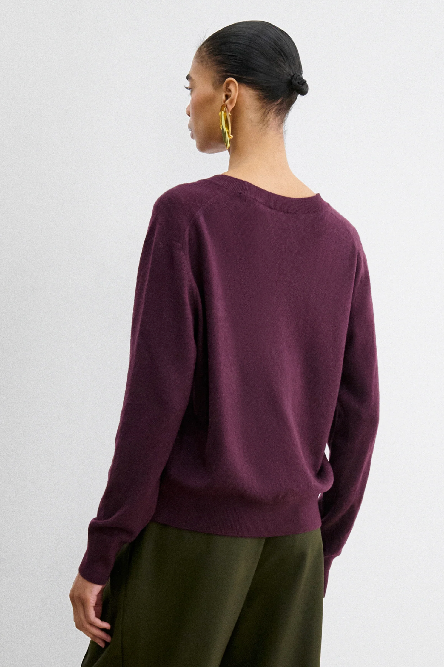 Rachel Comey Slate Pullover in slate gray paired with green pants, styled with gold hoop earrings and hair tied back.