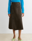 Rachel Comey Montrose Skirt in blue, styled with green heels on a beige floor for a modern, chic look.