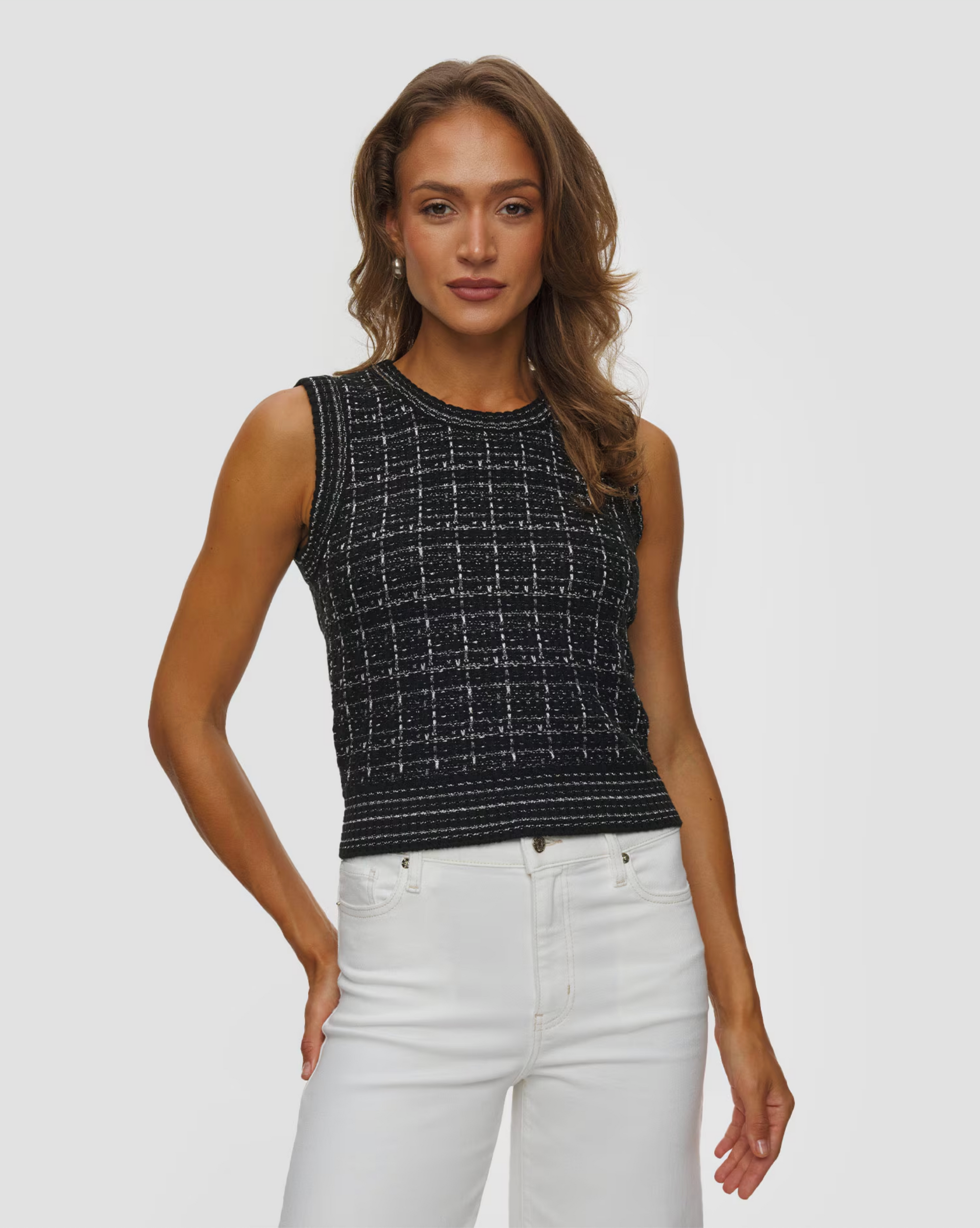 Gia Tweed noir knit sleeveless top by KUJTEN paired with white pants, styled in a minimal studio setting.