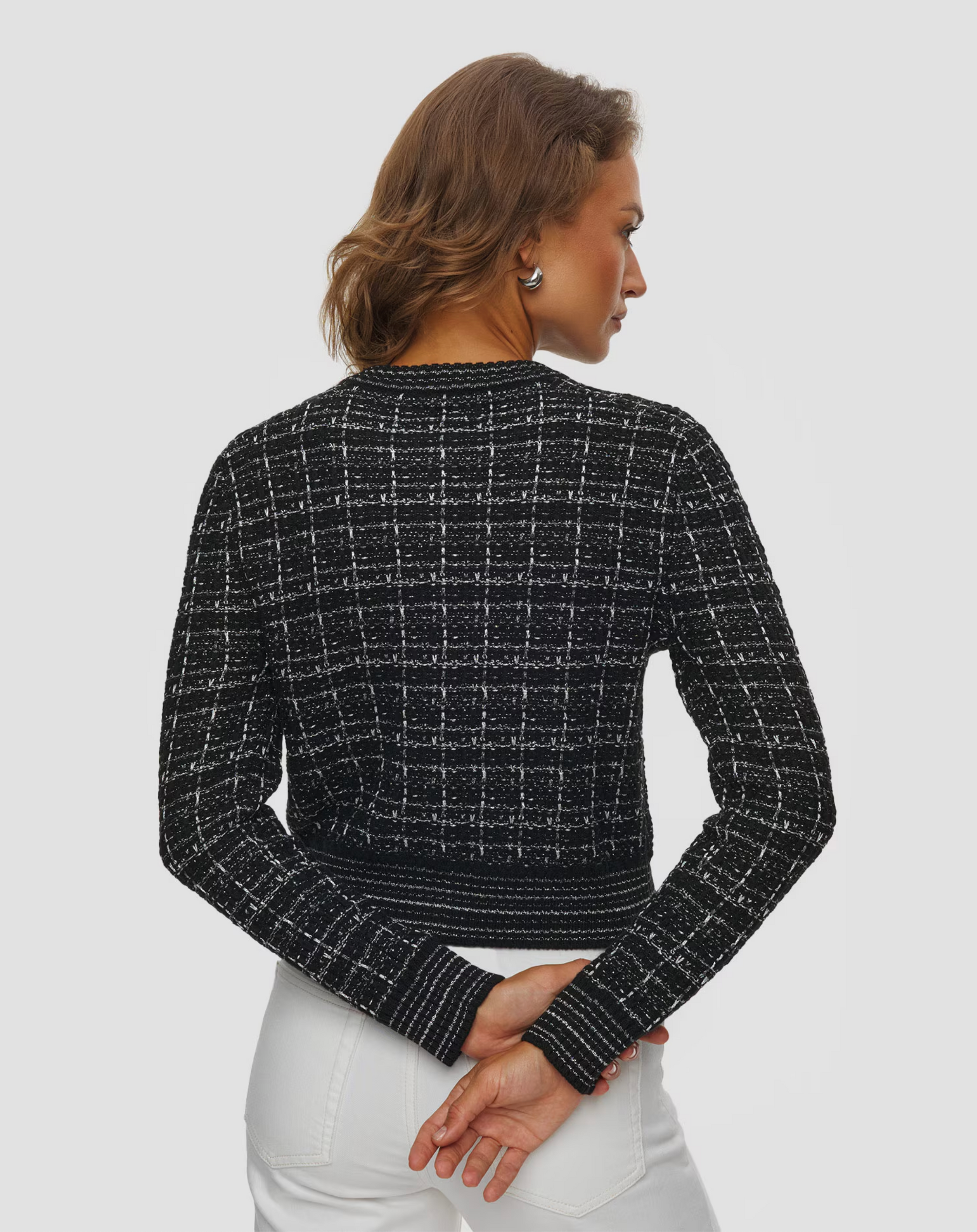 Black and white tweed Caroline Cardi by KUJTEN, shown from the back, styled in a chic, modern setting.