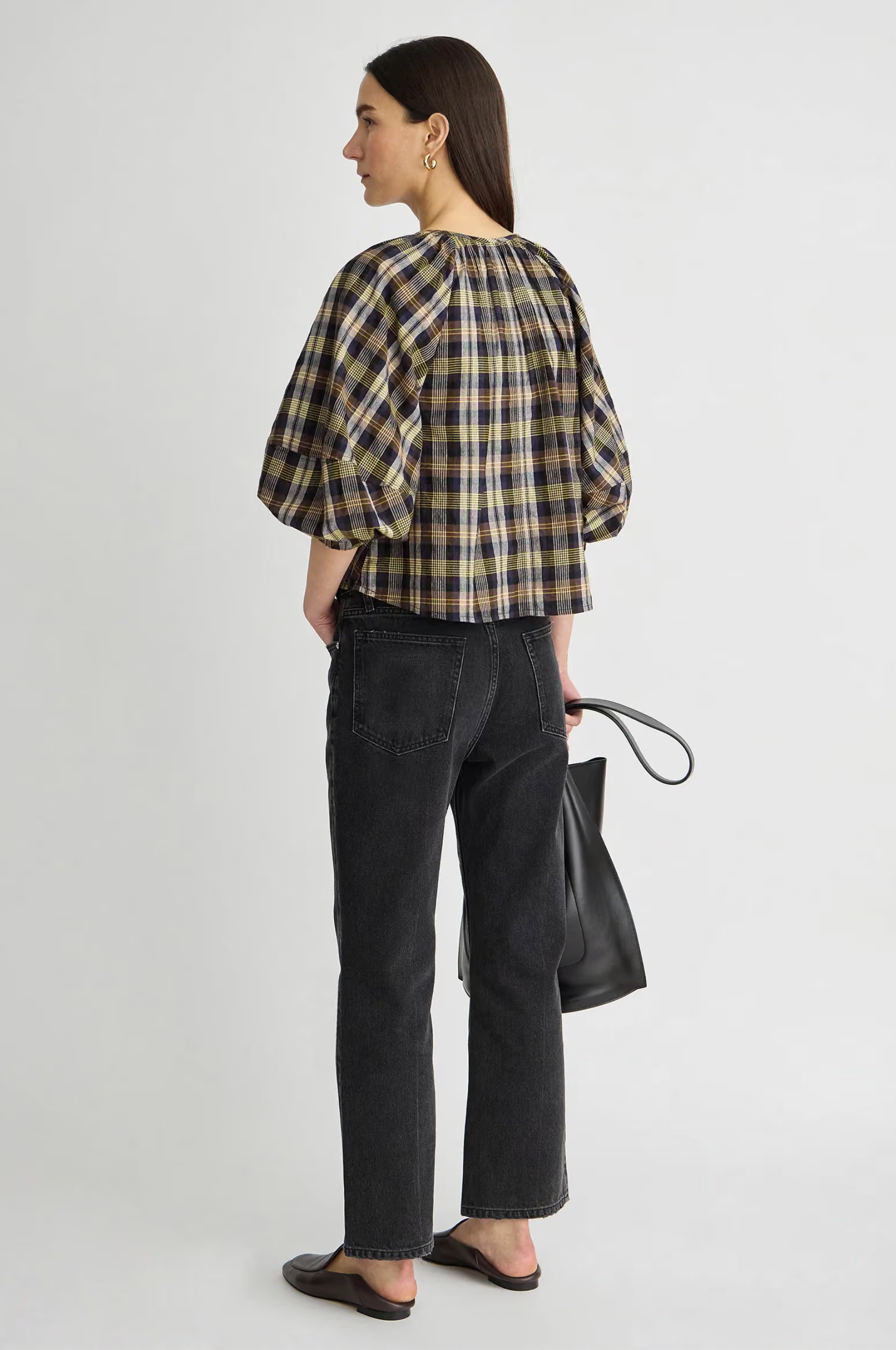 Apiece Apart Nele Lantern Sleeve Top in white, styled with black jeans and flats, model facing away.