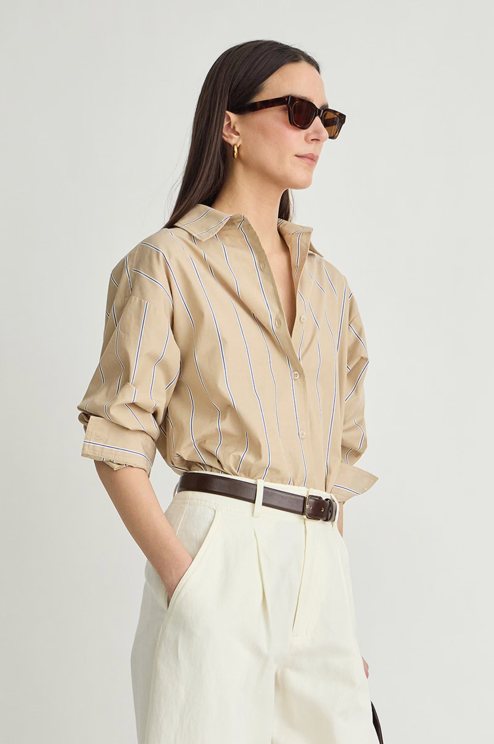 Apiece Apart Isolde Button Down shirt styled with white high-waisted pants and a dark belt, casual-chic look.