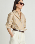 Apiece Apart Isolde Button Down shirt styled with white high-waisted pants and a dark belt, casual-chic look.
