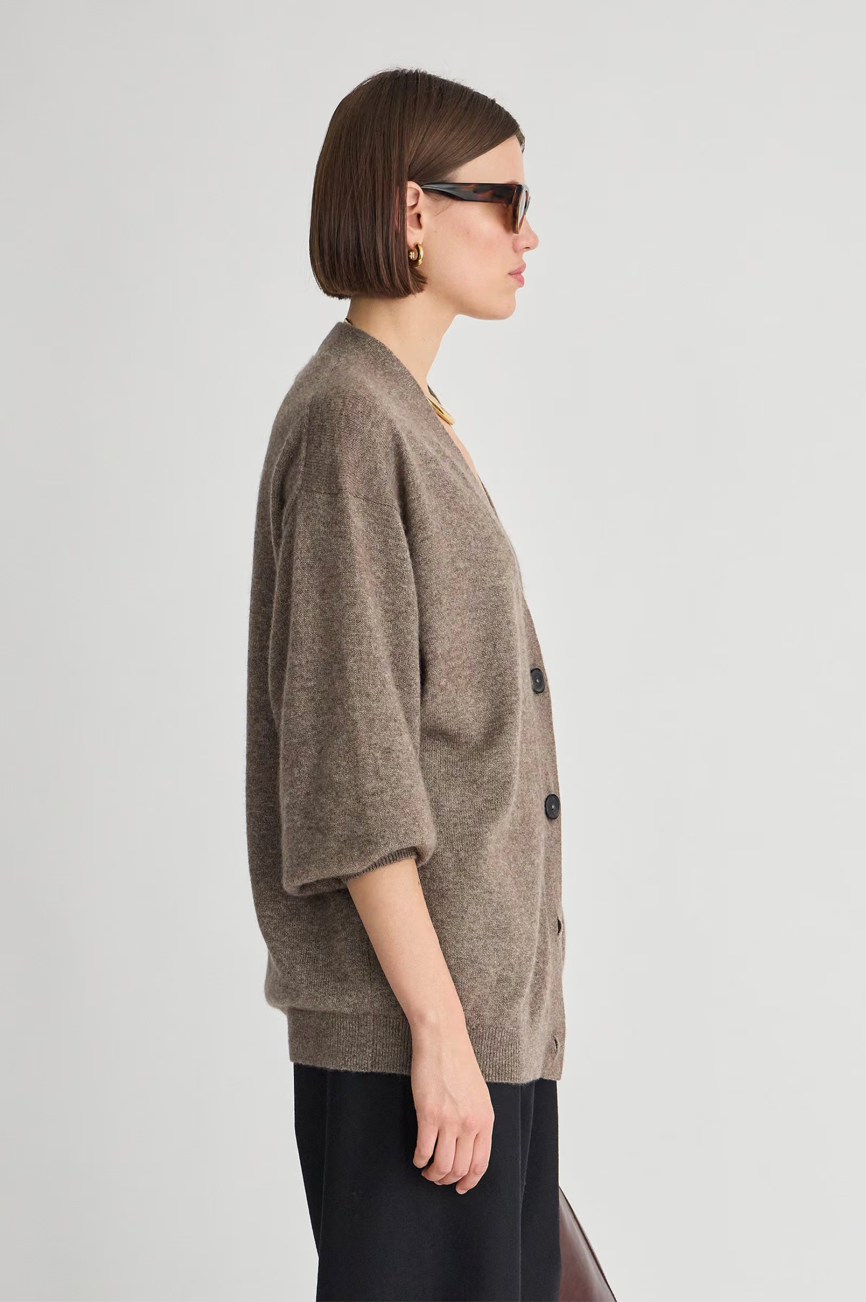 Apiece Apart Softest Tissue Weight Cardigan in light hue, styled on a woman in sunglasses, profile view.