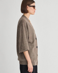 Apiece Apart Softest Tissue Weight Cardigan in light hue, styled on a woman in sunglasses, profile view.