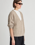 Apiece Apart silk cashmere V-neck marl sweater in soft hue, styled with white top and black pants.