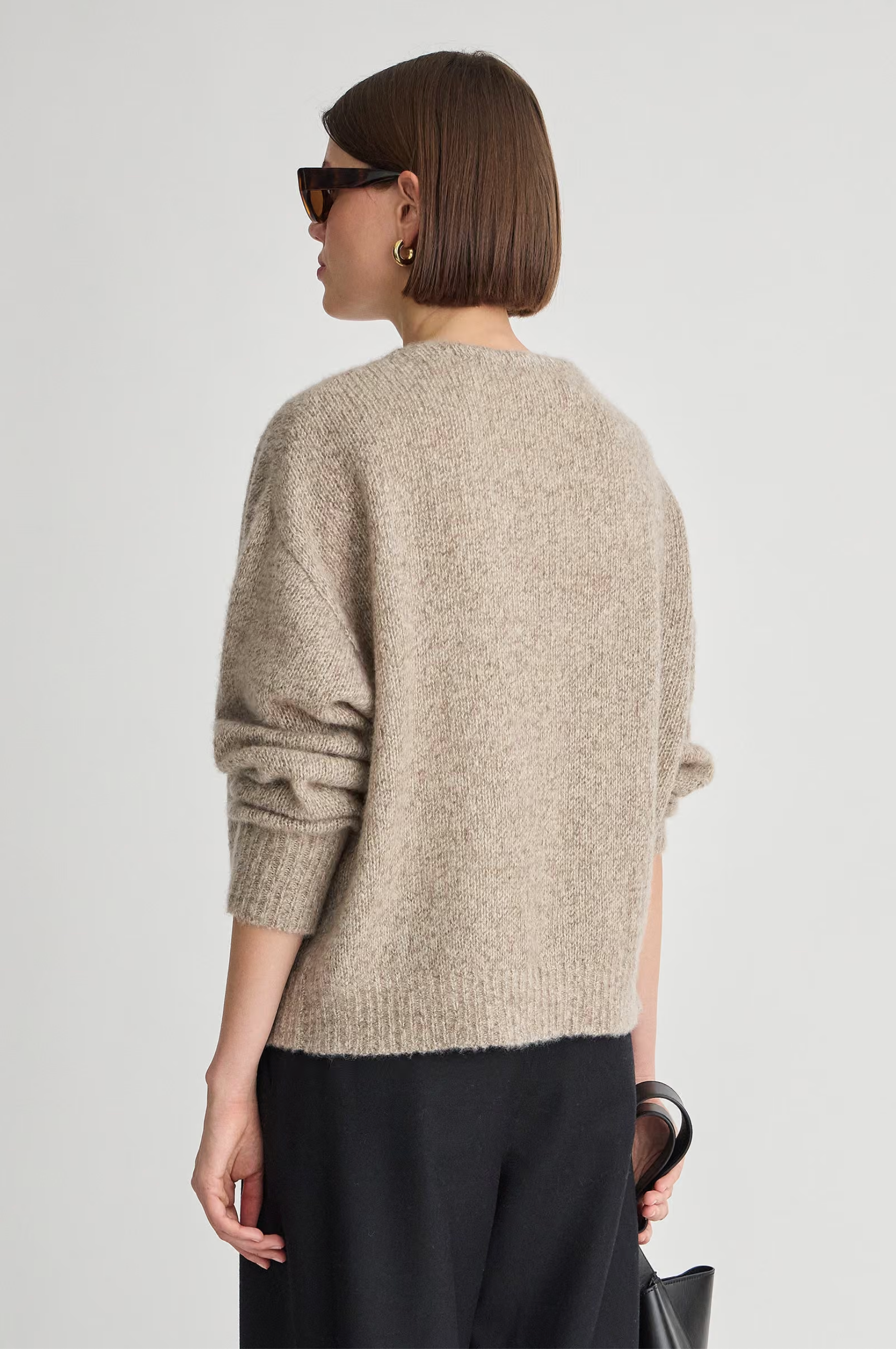 Apiece Apart Softest Silk Cashmere V-Neck Marl sweater in black, styled with sunglasses and black pants.