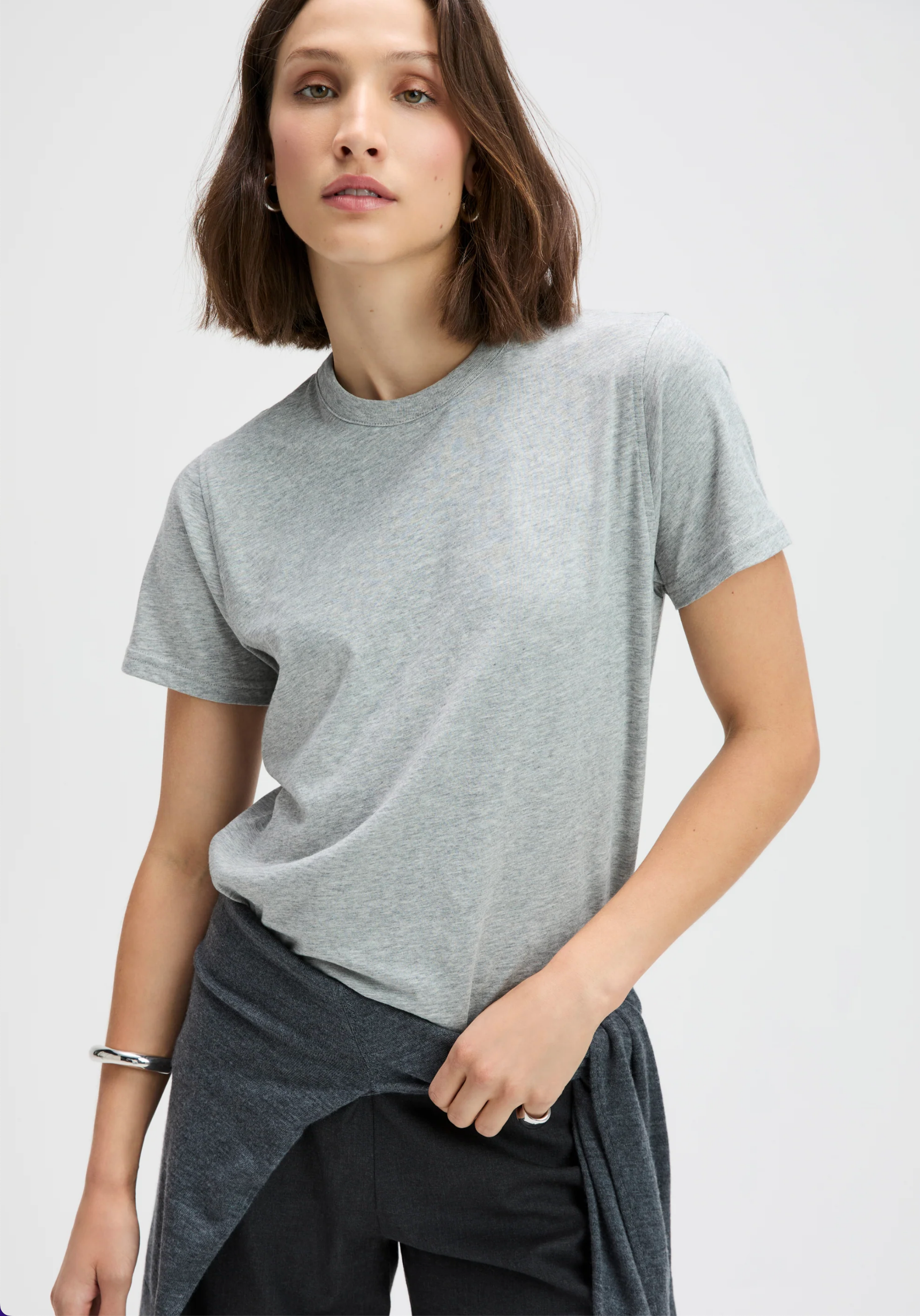 Heather grey relaxed-fit tee in organic cotton by Sold Out NYC, worn by woman with a brown bob hairstyle.