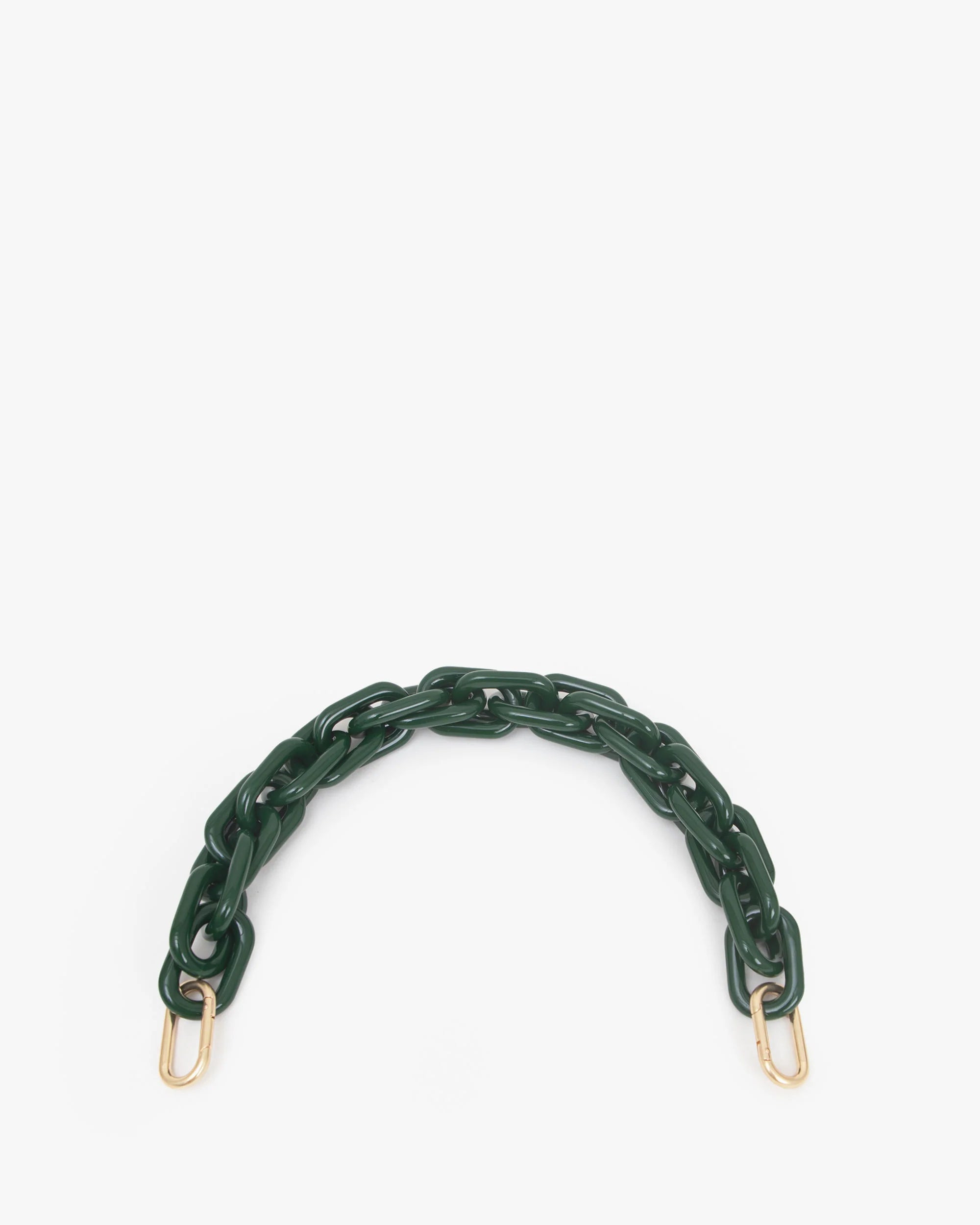 The Shortie Strap by Clare Vivier features a thick dark green resin chain with large semi-circular plastic links and gold-colored metal clasps on both ends. Perfect as a bag accessory, it contrasts beautifully against a plain white background.