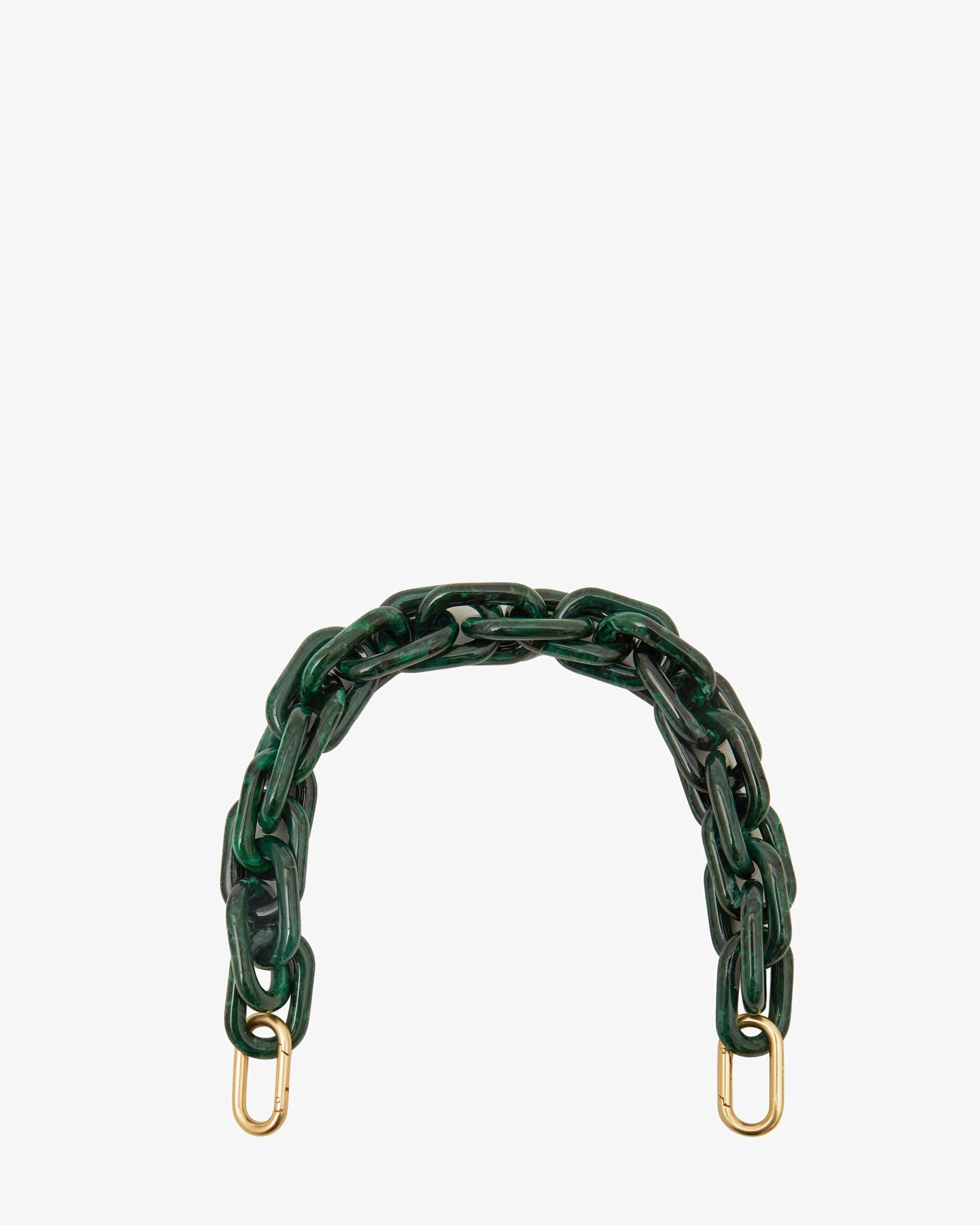 The Shortie Strap by Clare Vivier features a dark green resin chain with brass spring links and dual gold clasps at each end, designed as a chic bag accessory, set against a white backdrop.