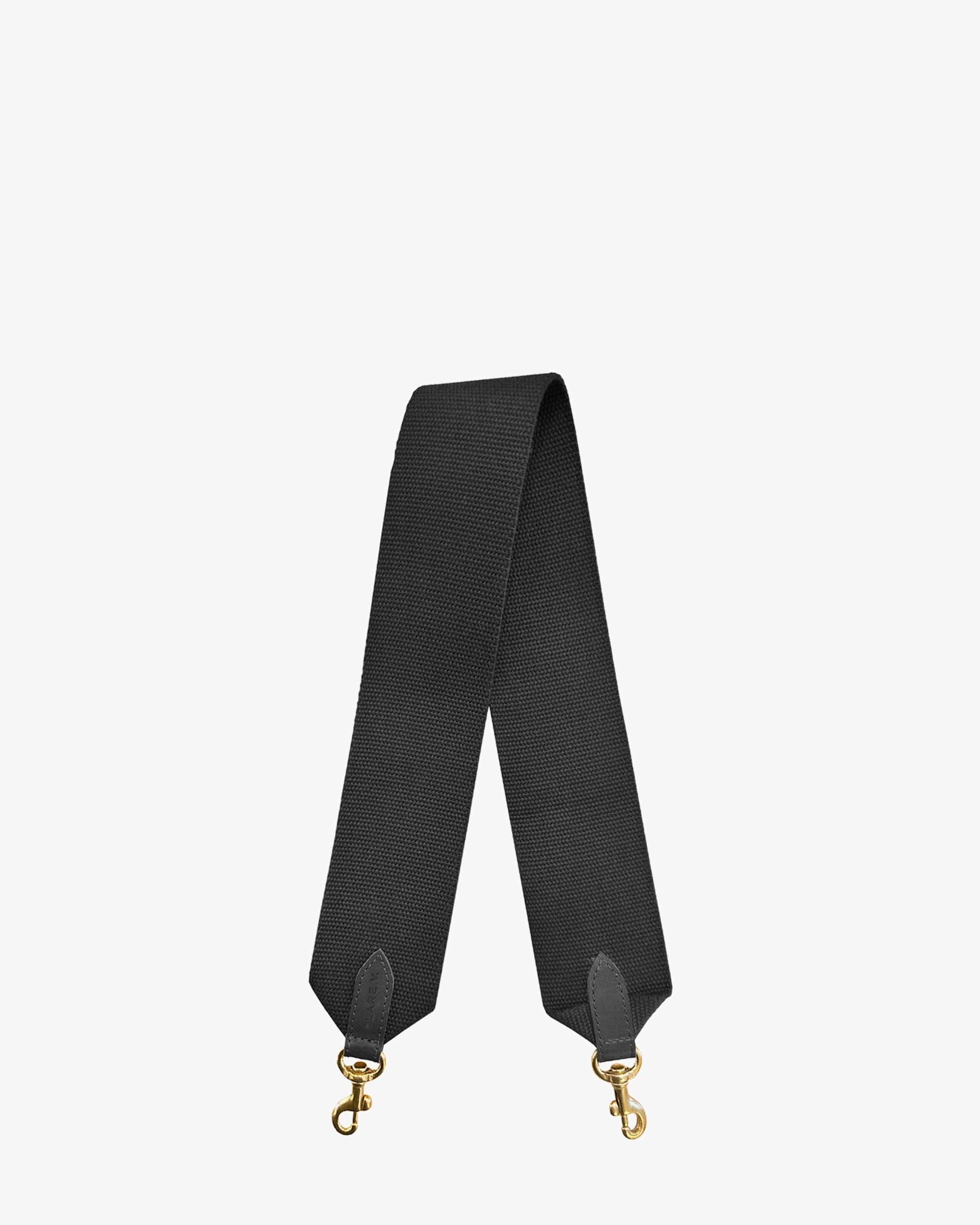 The Clare Vivier Shoulder Strap features a black cotton webbing with gold-tone clasps at both ends, showcasing a textured fabric. Made in L.A., the strap is positioned upright against a plain white background.