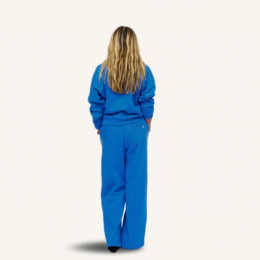 Blue Kerri Rosenthal super soft fleece shrunken sweatshirt and pants set modeled by person with long blonde hair.