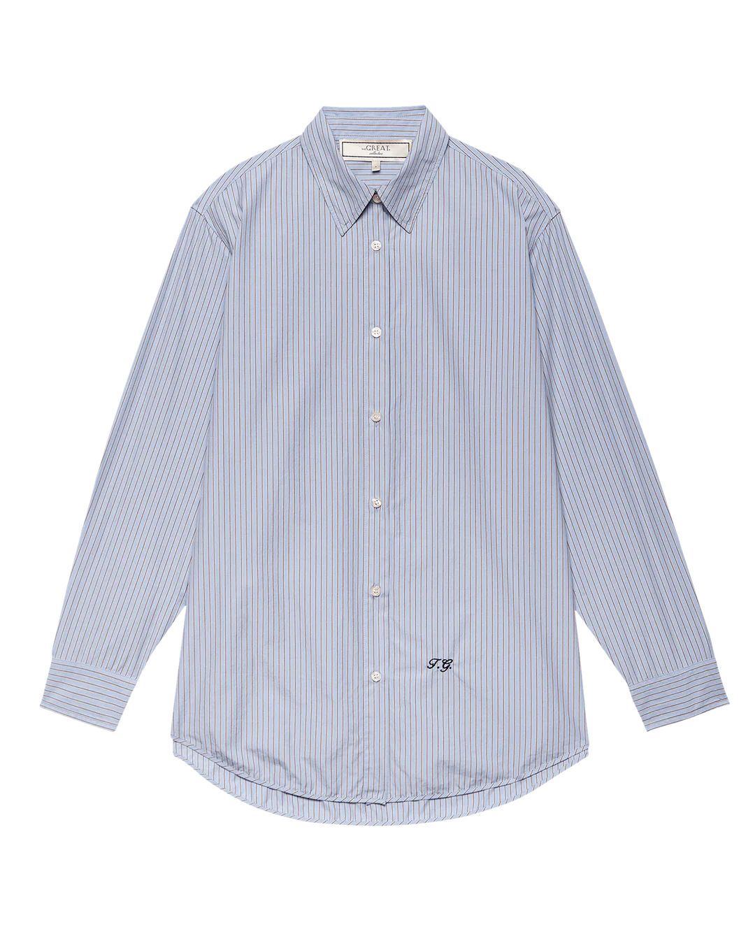 The Menswear Button Up by The Great Inc. features light blue and white vertical pinstripes, a collar, and a small embroidered monogram on the lower right front, inspired by vintage work shirts. Displayed on a plain white background.