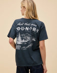 A woman with long blonde hair wears the DayDreamer Morgan Wallen Ain't That Some oversized cotton t-shirt, featuring white text and a scenic back graphic—perfect Morgan Wallen merch for fans. She faces away from the camera.
