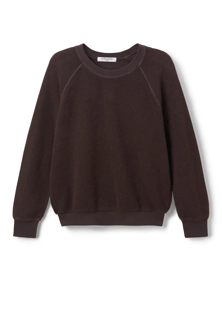 The Ziggy Reverse LS Sweatshirt by Perfectwhitetee is a dark brown, long-sleeved top made from soft cotton fleece with ribbed cuffs, hem, and neckline. Bracelet-length sleeves add a modern touch. Displayed on a white background.