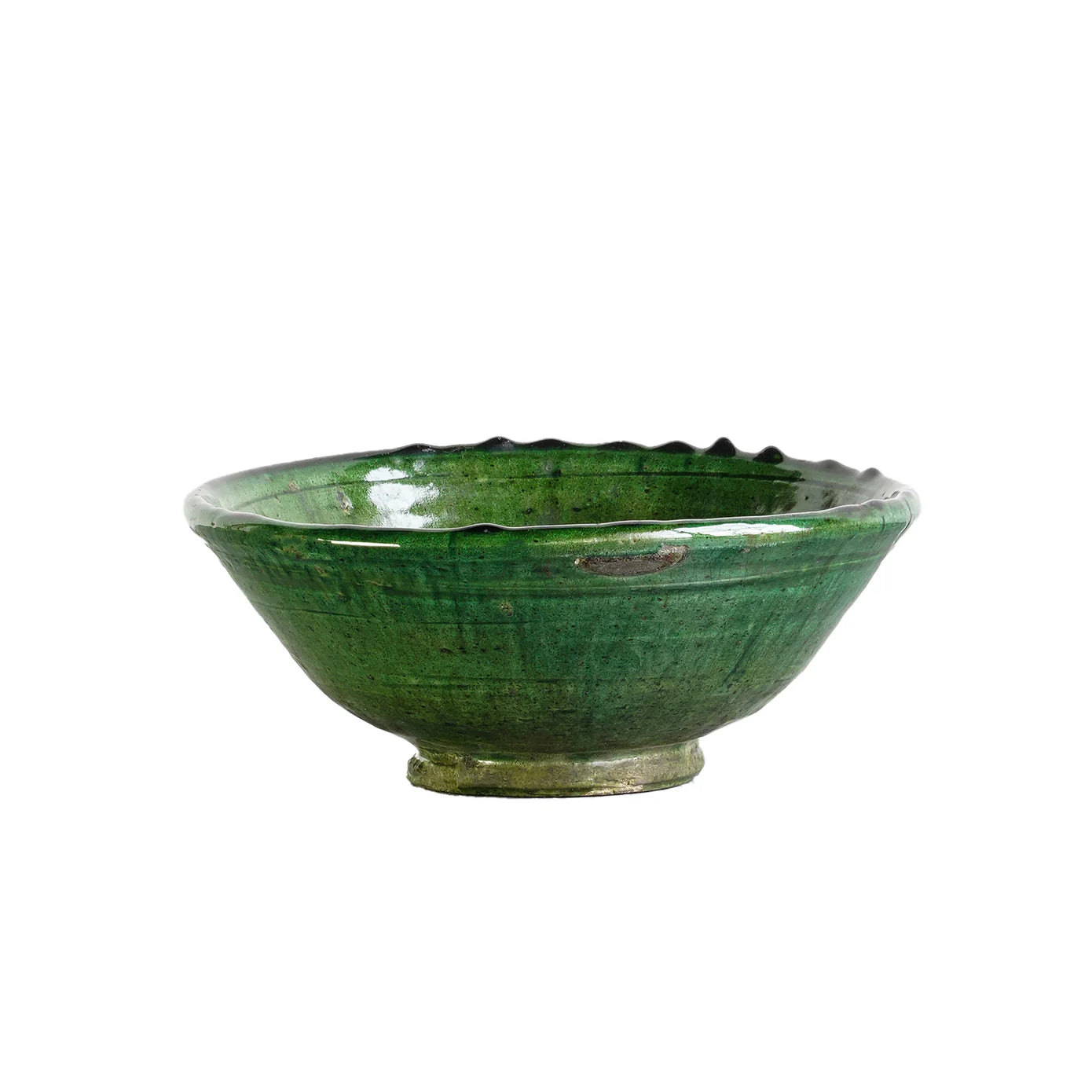 The Tamegroute Bowl by Blue Ocean Traders is a shallow, round piece with a small base and wide rim, finished in glossy green glaze. Its handcrafted ridges and texture create a striking accent against any plain white background.