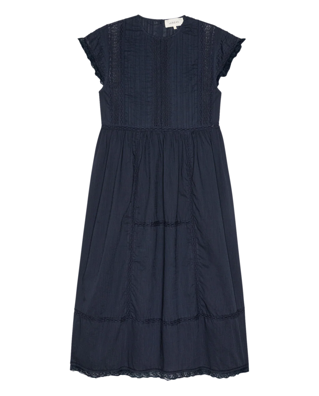 The Great Inc. Sonnett Dress is a navy blue knee-length cotton slub dress with lace pintuck detailing, short sleeves, fitted bodice, round neckline, subtle vertical pleats, and a back tag.