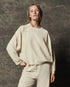 The Great Inc. Rehearsal Sweatshirt in gray, relaxed fit, modeled against a dark textured background.