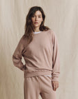 The Great Inc. College Sweatshirt 2026 in soft beige, casual fit, styled against a fabric backdrop.