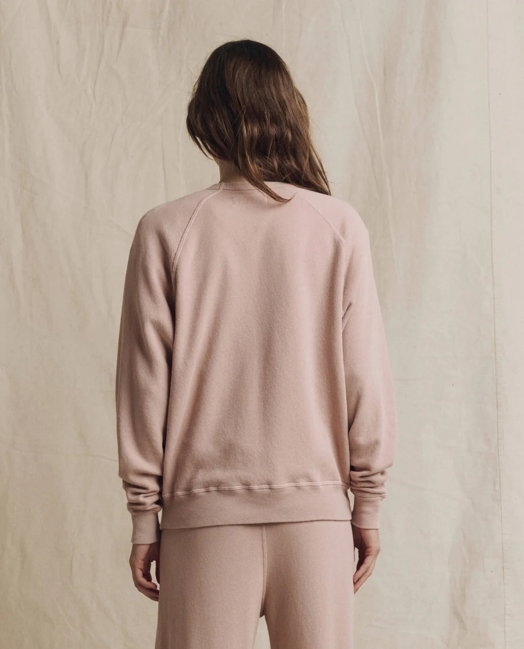 The Great Inc. College Sweatshirt 2026 in beige, shown from the back against a neutral fabric backdrop.