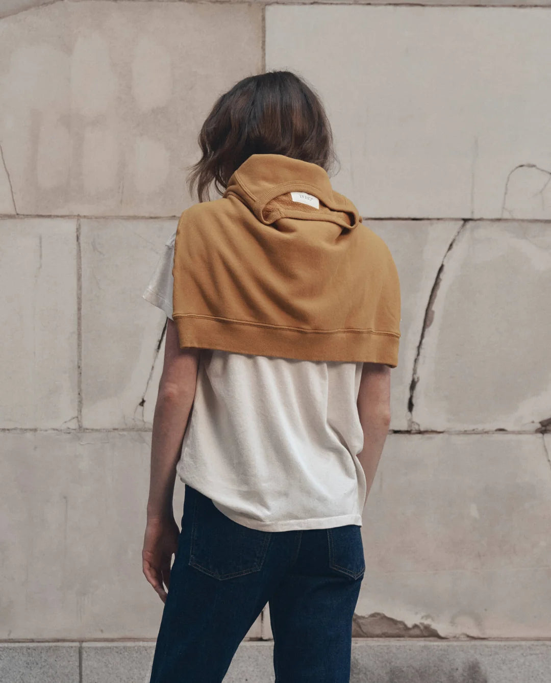 Boxy Crew Growling Panther tee and jeans styled with mustard sweatshirt, casual look by stone wall.
