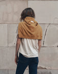 Boxy Crew Growling Panther tee and jeans styled with mustard sweatshirt, casual look by stone wall.