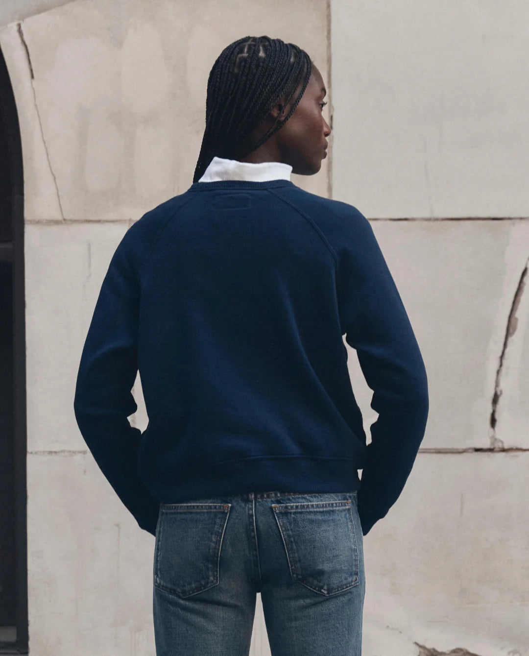 The Fleece Rookie Growling Panther jacket by The Great Inc. worn outdoors, back view, braided hair visible.