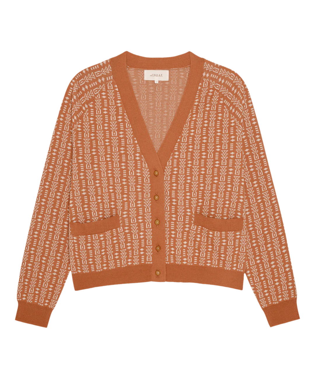 The Great Inc. Varsity Cardigan features rust-colored cotton, a geometric white pattern, V-neckline, button-down front, two pockets, and ribbed trims for vintage-inspired style. Shown laid flat on a white background.