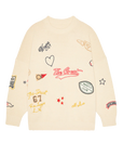 The Embroidered Oversize Crew by The Great Inc. is a cream cotton blend pullover, featuring colorful patch embroidery—stars, hearts, sports motifs, and varsity-inspired logos—for a playful take on vintage style.