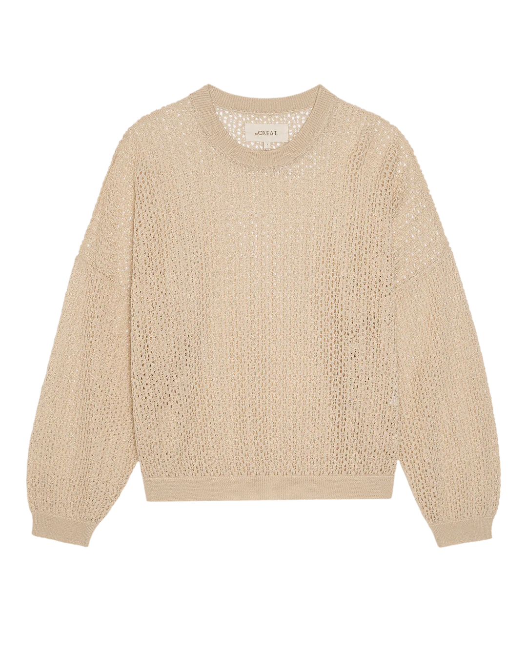 The Great Inc. "The Crochet Pullover" is a beige, long-sleeve crew-neck sweater with a loose open-weave crochet design and ribbed cuffs, hem, and neckline, shown flat on a white background.