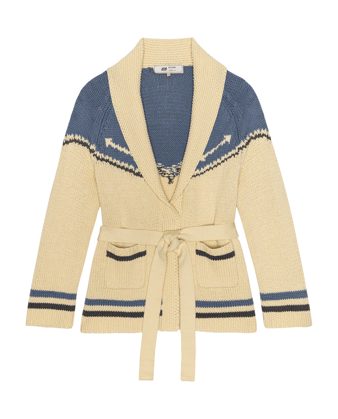 The Great Inc. presents The Western Riding Cardigan, a cream sweater with blue accents, shawl collar, geometric upper pattern, two front pockets, and tie belt at the waist. Garment shown against a white background.