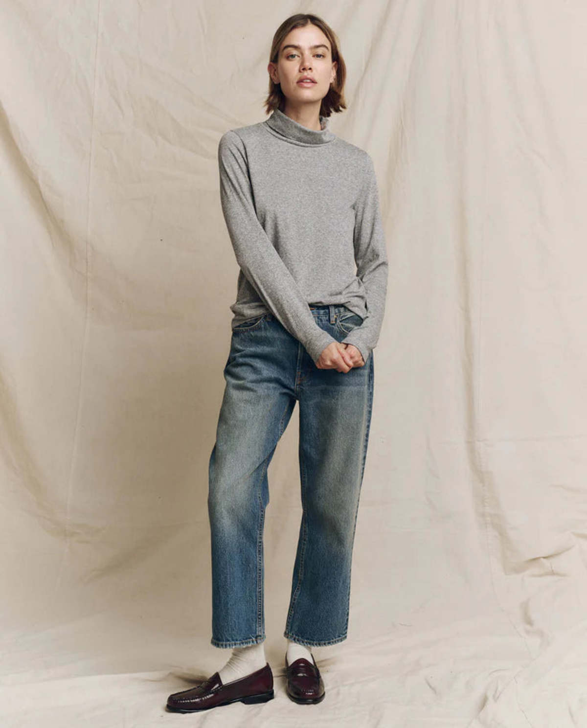 The Great Inc. Turtleneck paired with wide-leg blue jeans and dark loafers for a relaxed, classic look.