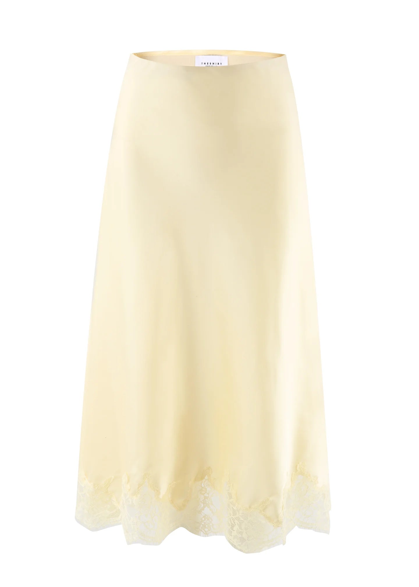 The Slip Skirt by THE SHIRT is a light yellow poly satin skirt with a subtle sheen and delicate lace hem, shown on a plain white background.