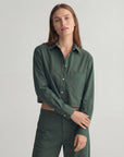 Dark green Harper Shirt and matching pants by THE SHIRT, worn by model against a plain light background.