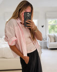 Kerri Rosenthal Tia Love Stripe Shirt with neon pink trim, styled casually with black pants in a modern setting.