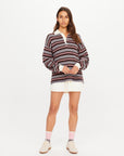 The Upside Wonder Knit Polo styled with a white pleated skirt and sneakers, casual look on white background.