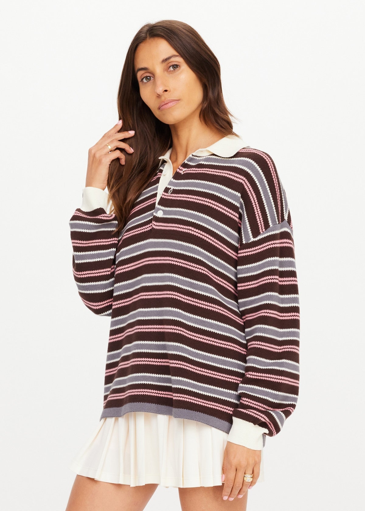 The Upside WONDER KNIT POLO in white, paired with a pleated skirt, modeled against a plain white background.