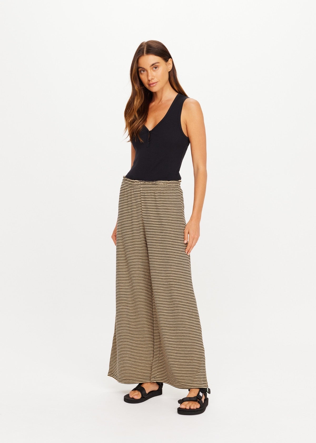 The Upside Santos Adriel Split Pant in black, styled with a sleeveless top, on model against white background.