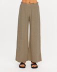 The Upside SANTOS ADRIEL SPLIT PANT in black, styled with black sandals, white background.