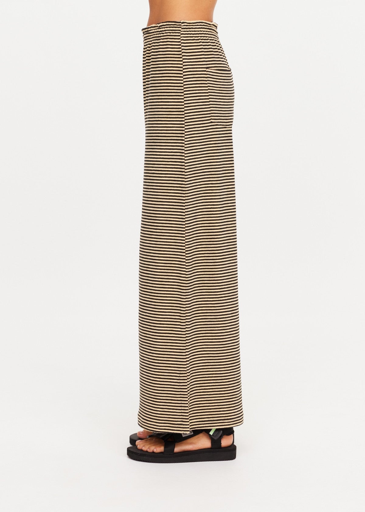 The Upside SANTOS ADRIEL SPLIT PANT in black, side view styled with black sandals.