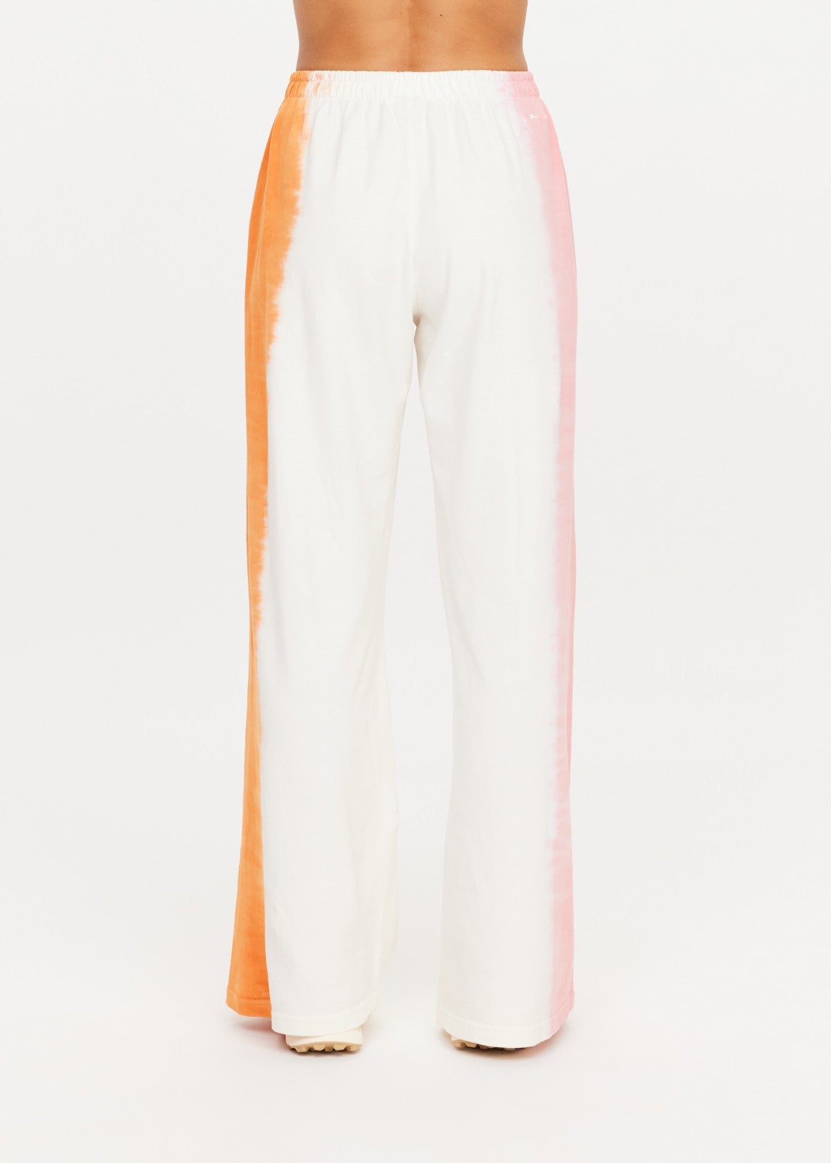 Orange-pink tie-dye wide leg pants in organic cotton from The Upside, viewed from the back.