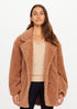 Gracie Teddy Coat in cream faux shearling by The Upside, styled over a beige sweater and black pants, studio backdrop.