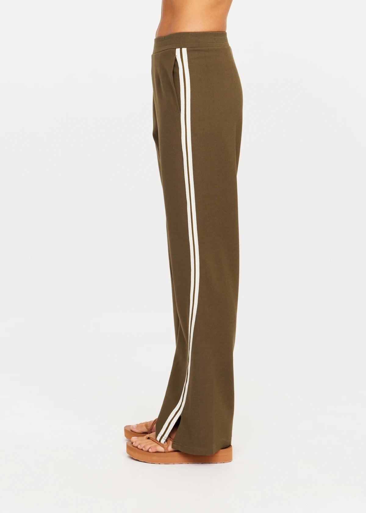Olive The Upside PETRA FLARE PANT with white stripes, shown side view with platform sandals.
