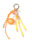The Venessa Arizaga Bag Key Leash features playful food charms—a hamburger, silver coin, pink dice, and three french fries—on a yellow and red cord, all attached to a metal keyring.