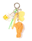 The Venessa Arizaga Bag Key Leash features playful food charms—beer mug, lemon wedge, French fry, “MOOD” letter beads, and a fried chicken drumstick—all dangling from a silver keyring for a fun accessory.