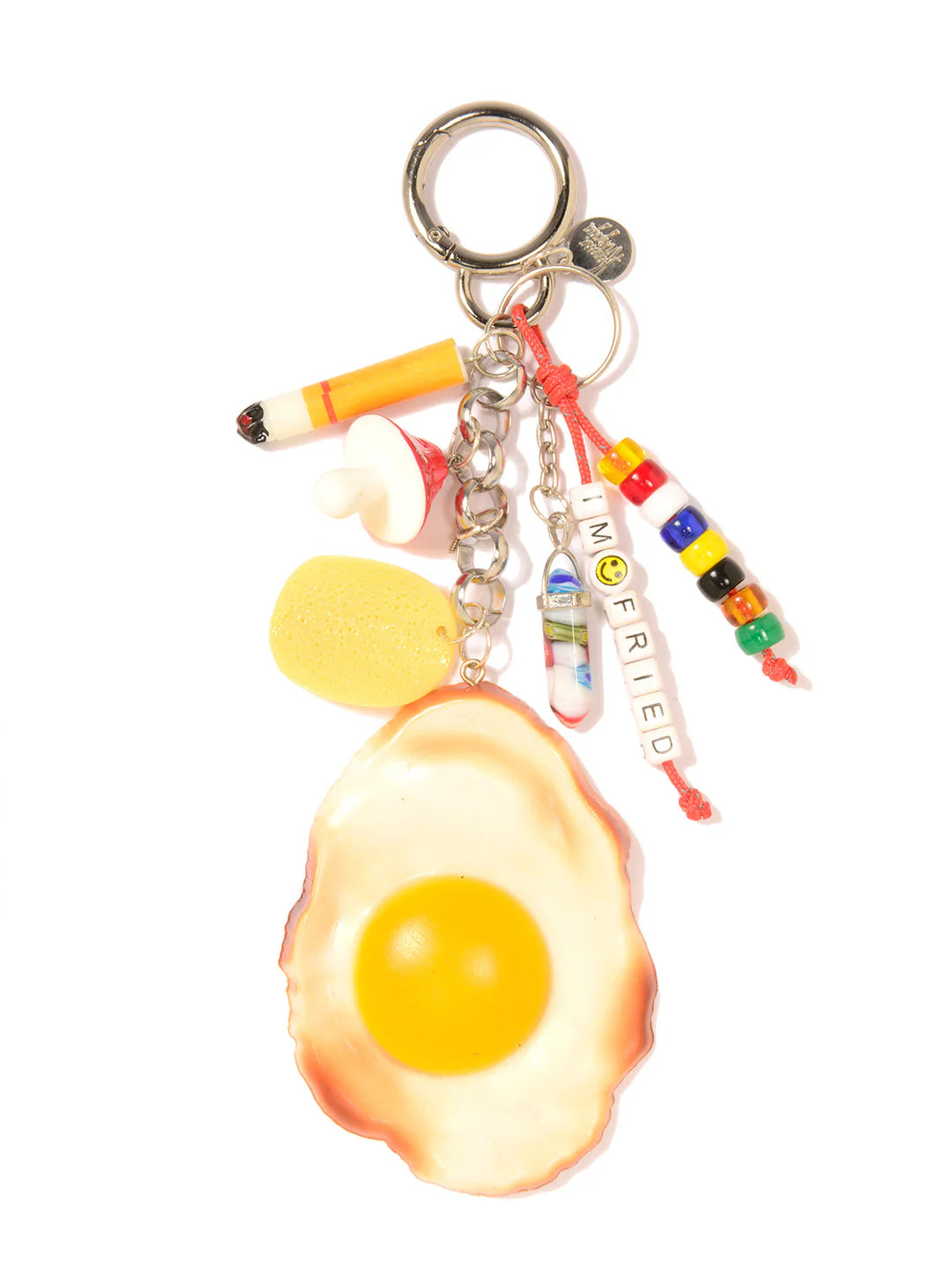 The Venessa Arizaga Bag Key Leash is a playful keychain bag charm with a large fried egg, cigarette, mushroom, yellow sponge, and colorful "NOT FRIED" beads—all attached to a sturdy metal key ring.