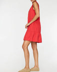A person in a sleeveless, knee-length red VIOLA DRESS by BROCHU WALKER stands in profile against a plain white background, wearing tan slip-on shoes.
