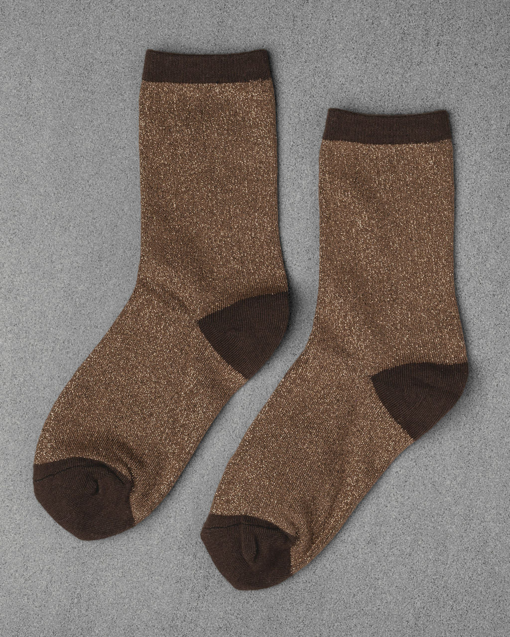 Unified Glitter Socks in brown feature darker brown toes, heels, and cuffs. Displayed flat on a gray textured surface.