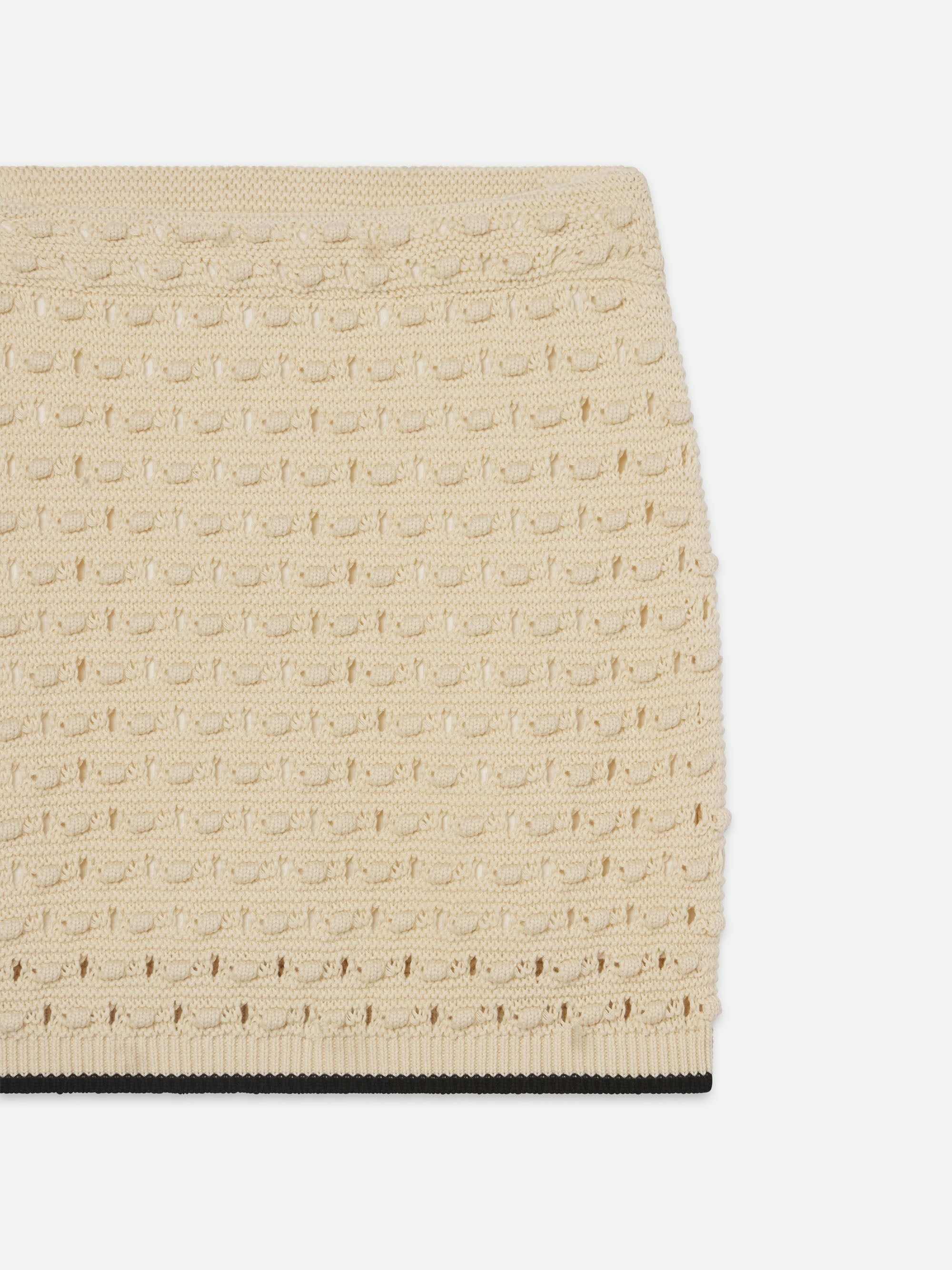 The Bauble Skirt by FRAME is a beige knit skirt featuring a bauble texture and subtle repeating pattern. Displayed against a white background, only the upper portion of the skirt is visible.