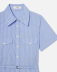 The Striped Safari Dress by FRAME features light blue and white cotton poplin, vertical stripes, front pockets, short sleeves, a pointed collar, and a thin black belt—an effortlessly chic summer choice.